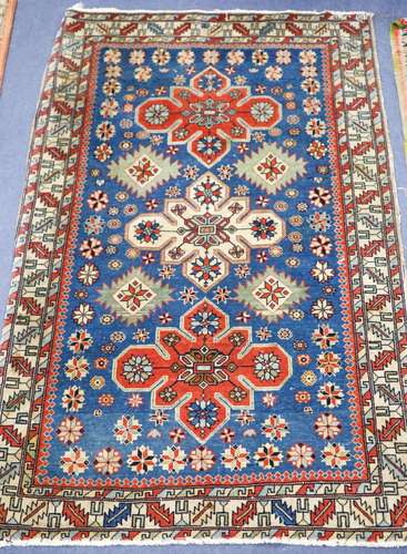 A Caucasian blue ground rug with triple medallions and geome...