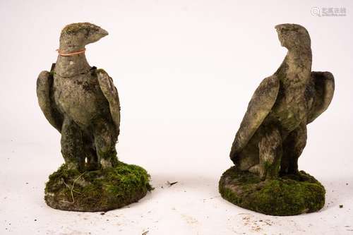 A pair of weathered reconstituted stone eagle garden ornamen...