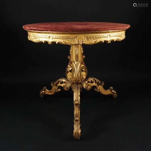 A carved gilt wood table with round top