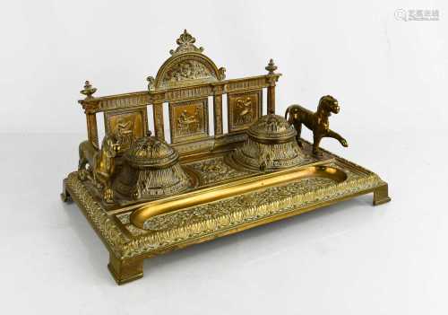 An Edwardian brass desk stand, cast with face masks and clas...