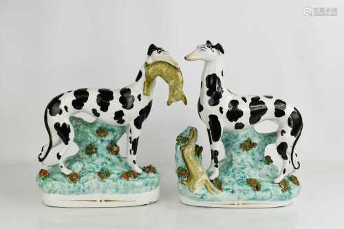 A pair of 19th century Staffordshire greyhounds, with hares,...