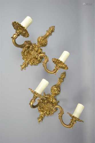 A pair of brass wall sconces with scroll decoration