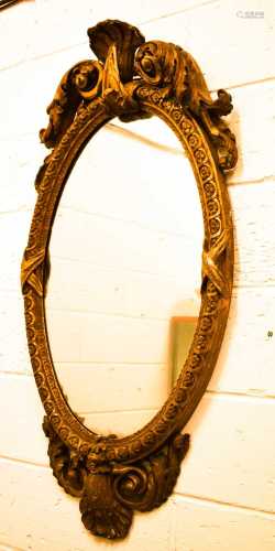 A large 18th century oval wall mirror with scroll work crest...