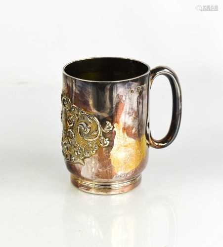 A silver mug, embossed with a crest and engraved with a mono...