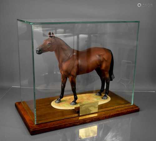 A 20th century porcelain model of Red Rum, in a glass case o...