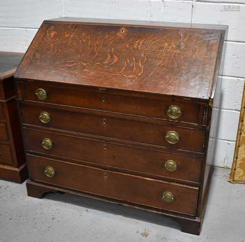 A Georgian oak bureau with full front enclosing an interior ...