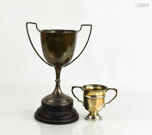 Two silver trophies, one raised on an ebonised plinth, both ...