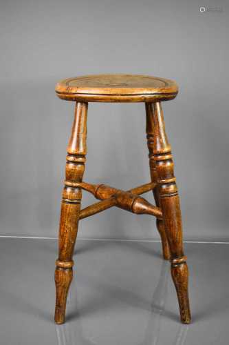 An early 19th century oak stool with circular top and x stre...