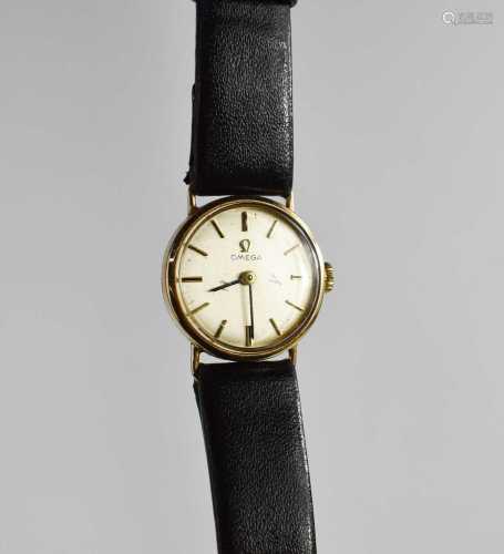 An Omega 9ct gold wristwatch, with black leather strap, in t...