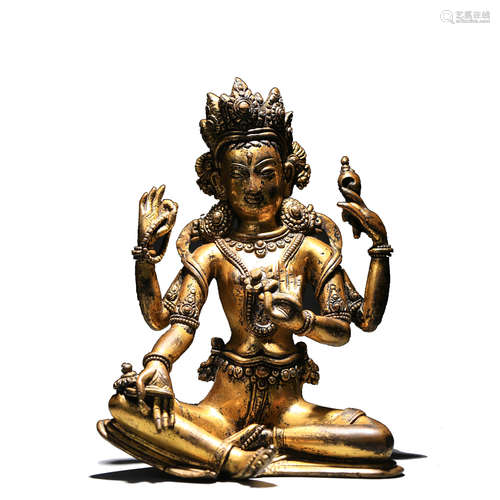 A GILT BRONZE FIGURE OF FOUR-ARMED GUANYIN