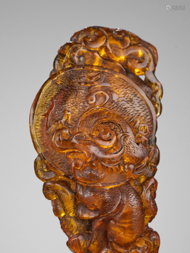 A CARVED AMBER 'DRAGON' PENDANT, EARLY QING