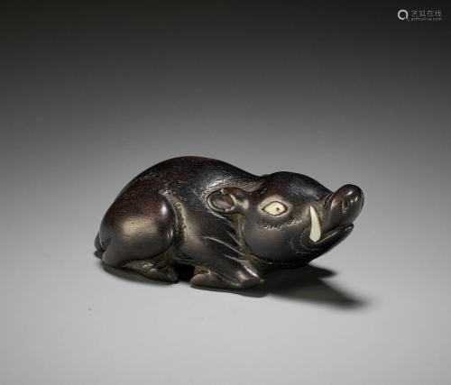 A LARGE DARK WOOD NETSUKE OF A RECUMBENT BOAR