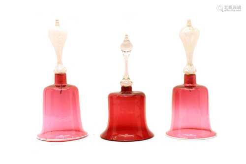 A near pair of large cranberry glass bells,