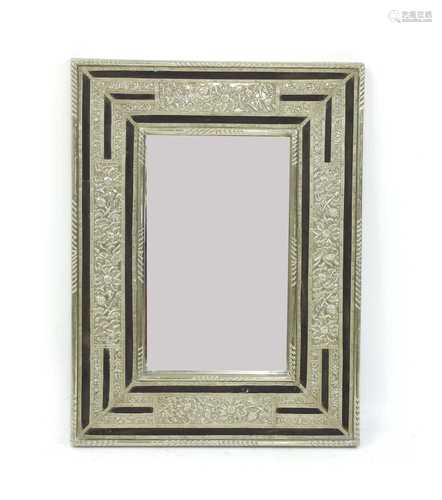 An ebony and silvered metal-clad mirror,