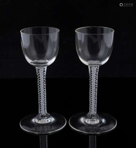 A pair of Georgian glasses with white double air twist stems...