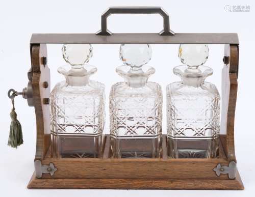 An antique English tantalus set, oak and nickel plate with t...