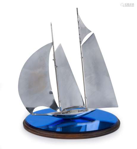 An Art Deco chrome yacht ornament on timber and blue glass b...