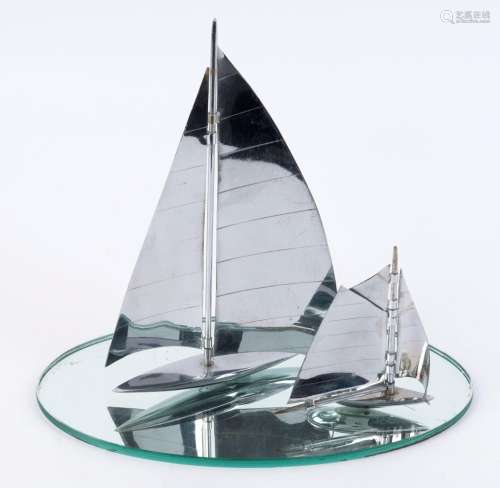 Two chrome yacht ornaments together with an oval mirrored gl...