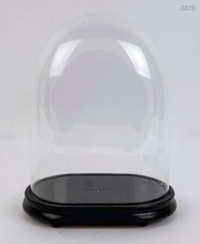 A large oval French glass dome on ebonised ogee moulded timb...