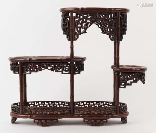 A Chinese four tier display stand, carved rosewood with pier...
