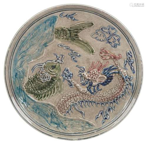 An antique Korean ceramic charger with dragon and fish desig...