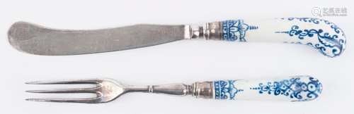 An antique knife and fork with blue and white porcelain pist...