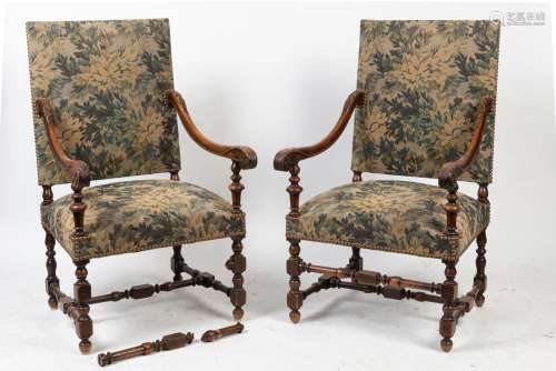A pair of antique French carved walnut armchairs upholstered...