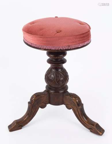 An antique revolving piano stool, carved walnut with dusty p...