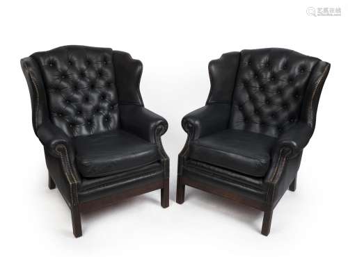 A pair of Georgian style wingback armchairs with black studd...