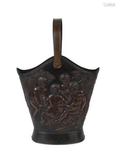 An antique embossed metal umbrella stand with cupid decorati...