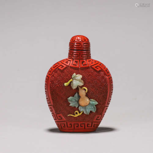 A gem-inlaid carved lacquer snuff bottle