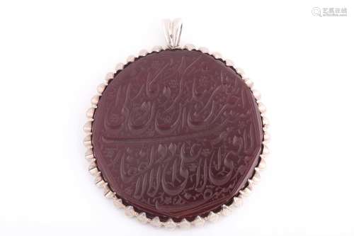 An Indo Persian red hardstone pendant in silver metal mount