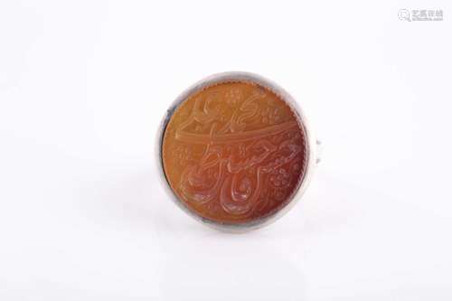 An Indo Persian white metal and orange stone ring