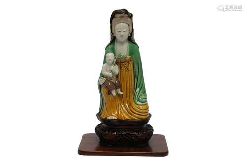 A CHINESE SANCAI-GLAZED BISCUIT 'GUANYIN AND CHILD'...