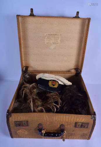 A VINTAGE SUITCASE containing a military hat, wigs etc.