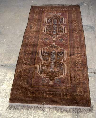 A MIDDLE EASTERN BROWN GROUND RUG, decorated with