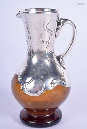 AN ART NOUVEAU SILVER OVERLAID GLASS JUG decorated with