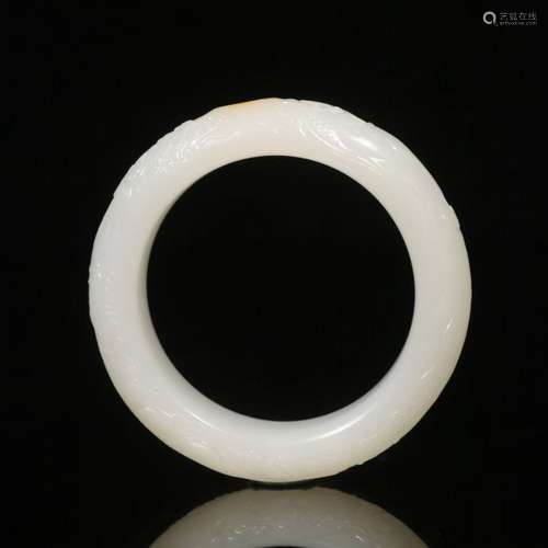 A CARVED WHITE JADE BANGLE