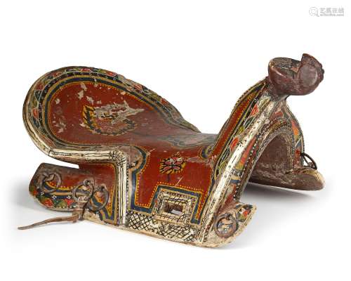 A POLYCHROME-PAINTED AND LACQUERED WOODEN SADDLE,