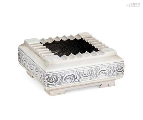 A square silver ashtray with repousse scroll decorated sides...