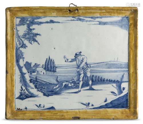 A Delft blue and white plaque, c.1760, decorated with a land...