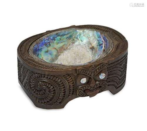 A MÄori carved wood box, inset with abalone shell and carve...