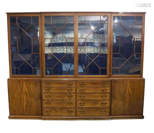 A George III style mahogany breakfront bookcase, in the mann...