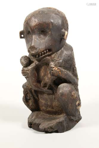 Indonesia, Sumatra, carved wooden squatting monkey holding t...