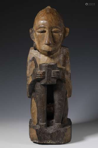 Nias, a squatting male ancestor figure in an unusual positio...