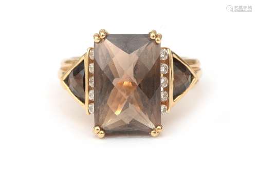 An 18 karat gold smokey quartz and diamond ring. Featuring a...