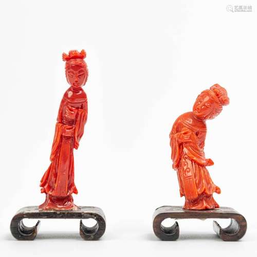 A pair of small sculptures made of red coral.