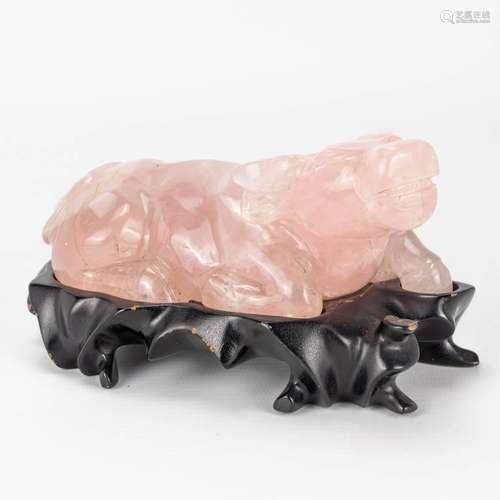 A buffalo figurine sculptured from pink quartz and resting o...