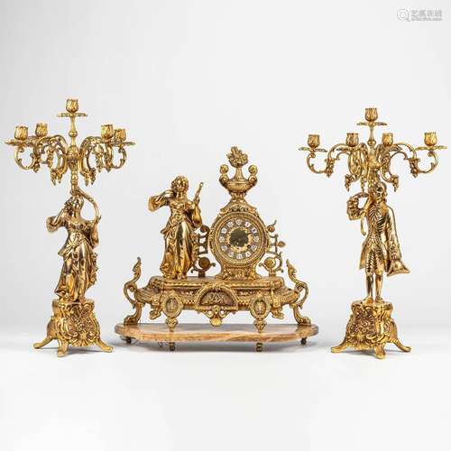 A three-piece mantle clock with candelabra, made of bronze s...