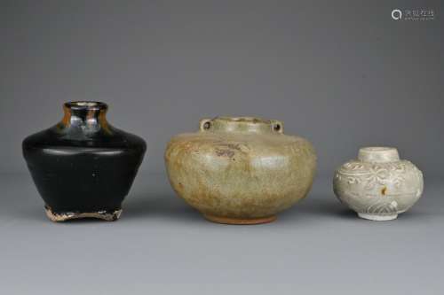 Three Southeast Asian pottery jars. One covered in a